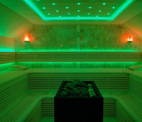 Sauna mit Holzbänken in grünem Licht
